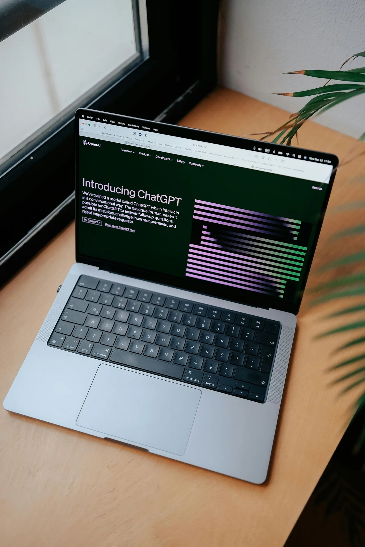 Laptop displaying a code editor beside a window.