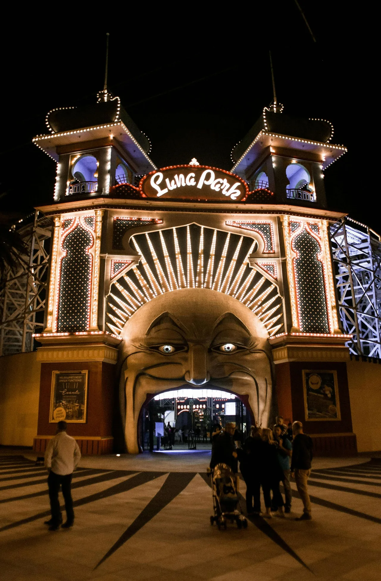 Visitors outside the Luna Park entrance at night.